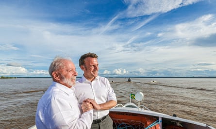 Lula and Emmanuel Macron holding hands on a boat in March 2024