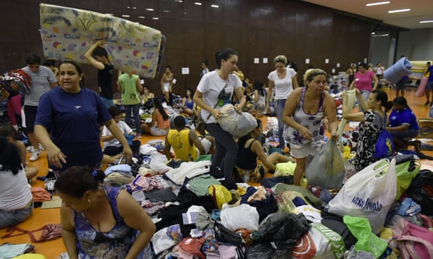 People gather at the Arena Mariana, in Mariana, after a dam burst, forcing residents from their homes.