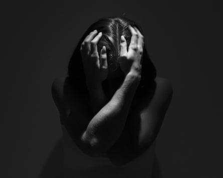 Woman clutching her head in mental anguish.GettyImages-2102053017