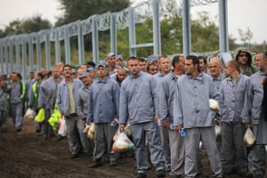 Hungarian prisoners form part of a work detail to finish the razor wire border fence with Serbia.