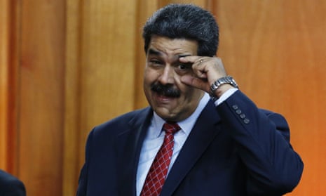 Nicolás Maduro gestures to military leaders to keep their eyes open at the end of a press conference inside the presidential palace in Caracas, Venezuela, on 25 January.