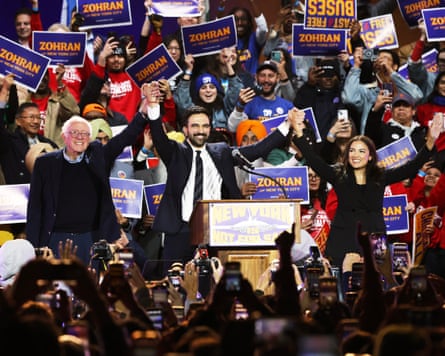 Bernie Sanders, Zohran Mamdani and Alexandria Ocasio-Cortez look connected shape during a rally