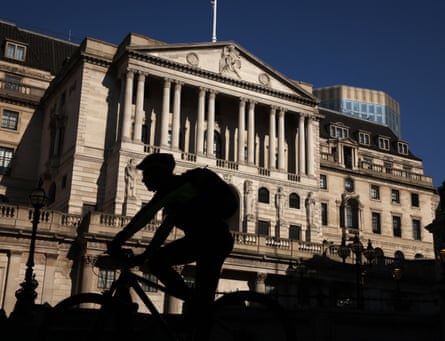 A cyclist rides by the Bank of England