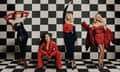 Nicola Roberts, Cheryl, Kimberley Walsh and Nadine Coyle dressed in smart red and black outfits and photographed against a chequerboard background