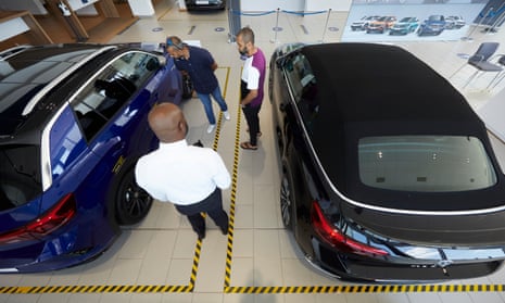 Sajul Islam and a friend look at cars at a Volkswagen dealership in Loughton, Essex. 