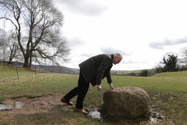 A man touches the boundary stone in Eyam from which no resident could pass during the village’s isolation in 1666.
