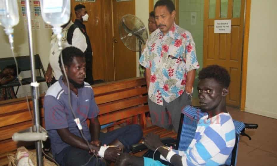 Dominic Stally (left) and another survivor talk to John C Balavu (centre), the Papua New Guinean high commissioner to the Solomon Islands at the National Referral Hospital in Honiara after their rescue.