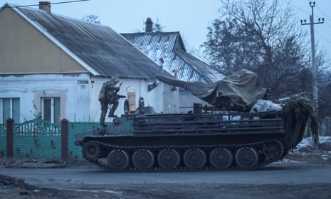A Ukrainian serviceman climbs onto a military vehicle in the front line city of Bakhmut.