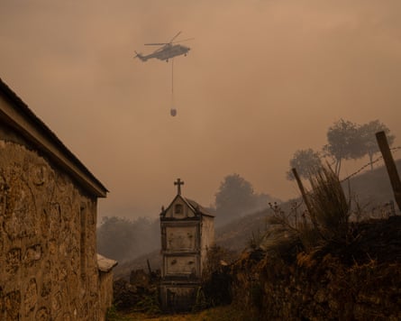 helicopter flies over chapel in smoky skies