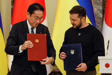 Zelenskiy and Kishida hold documents as they attend a joint news conference.
