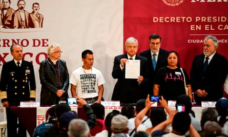 Mexico’s President Andres Manuel Lopez Obrador shows the signed decree to investigate the case of 43 missing students, during a ceremony with relatives of the students, at the National Palace in Mexico City on Monday.