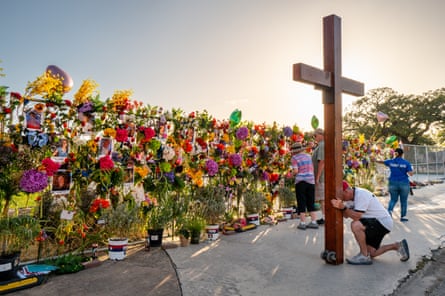 People grieve and pay their respects at a memorial