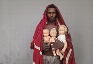 A portrait of a man holding dolls found in rubbish by men and women living in the favelas who have been unemployed for four years in Rio de Janeiro, Brazil