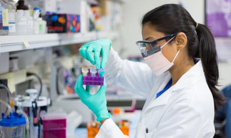 Closeup portrait, young scientist in labcoat wearing nitrile gloves, doing experiments in lab, academic sector.<br>EM277F Closeup portrait, young scientist in labcoat wearing nitrile gloves, doing experiments in lab, academic sector.