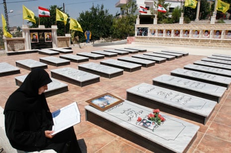 A woman reads the Qur’an in a cemetary