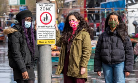 Activists with a road sign by Choked Up, an anti-pollution campaign in London backed by doctors.