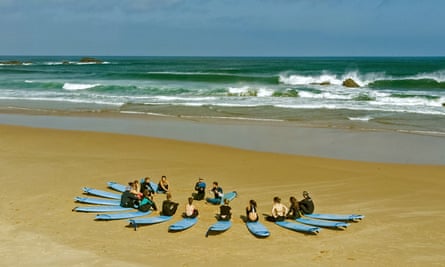 Surfers sitting on beach on Algarve beach