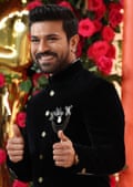 Ram Charan, with medal-like decorations on his lapel, giving a thumbs-up