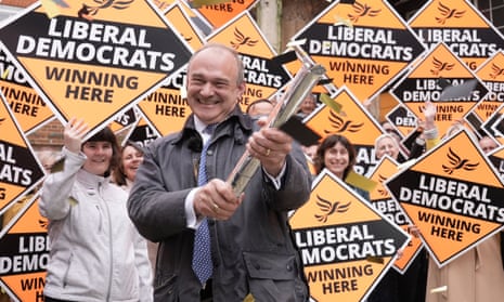 Ed Davey grins while surrounded by people carrying signs saying 'Liberal Democrats, winning here'