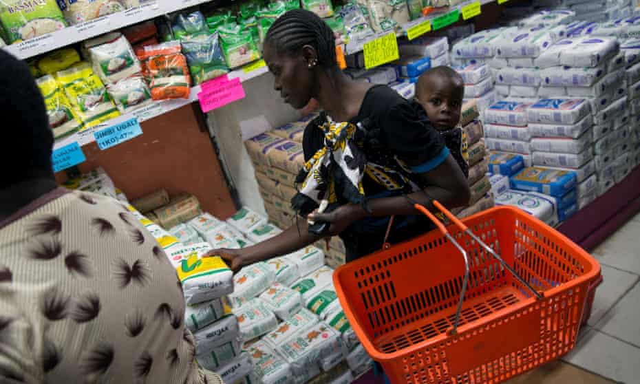 A woman picks up a packet of government-subsidised maize flour at a supermarket in Nairobi