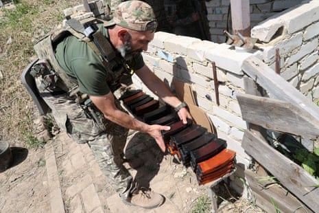 A member of service personnel stacks up magazines in Kharkiv region during training.