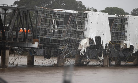 Workmen inspect the flood-damaged Martin Bridge across the Manning River at Taree on the NSW mid-north coast on Tuesday. 