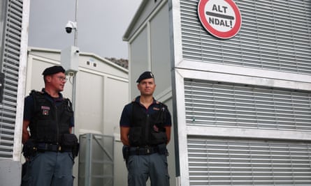 Two Italian officers at opening in high fence