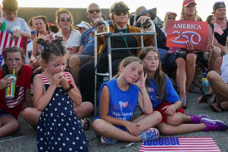 Children sit on the ground at the Iowa rally.