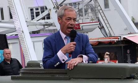 Nigel Farage in a military-style vehicle speaking into a mic