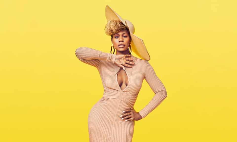 Laverne Cox in hat and beige dress