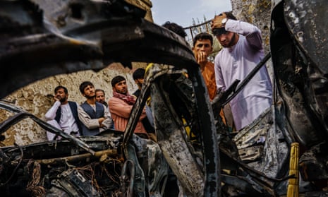 Neighbours and relatives crowd around a vehicle destroyed by an American drone strike in Kabul in late August.