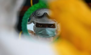 An MSF medical worker checking their protective clothing