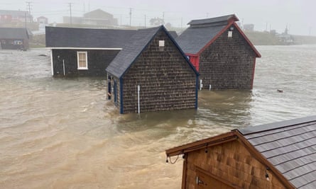 Water levels rise around single-storey wooden huts after the hurricane
