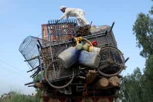 A man adds more belongings to a truck already heavily laden