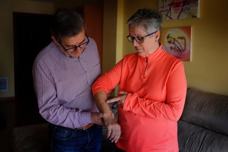 Luisa Rico with her husband, Jaime Abrio, pointing to the scar on her arm where she was shot.