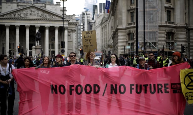 Extinction Rebellion protesters hold up  a ‘No food/no future’ banner outside the Royal Exchange in London