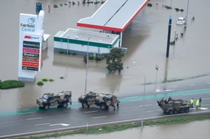 Armoured vehicles on a flooded road in the Townsville suburb of Idalia