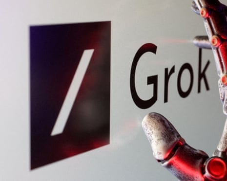 Robotic hand touching screen displaying Grok logo.