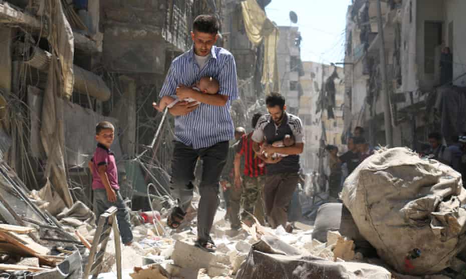 Syrian men carrying babies make their way through a destroyed neighbourhood of Aleppo.