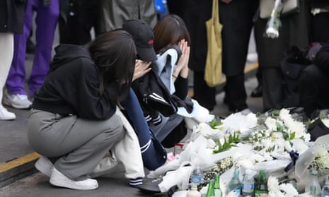 Women pray for victims of a deadly accident following Saturday night's Halloween festivities on the street near the scene in Seoul.