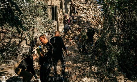 Volunteers in the rubble of a building looking for survivors after a strike in Zaporizhzhia.