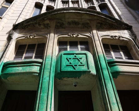 Synagogue entrance with part of it vandalised by spray-painting in green.
