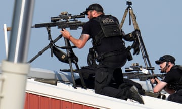 police on a roof wearing black with snipers