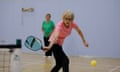 Four people in athletic clothing play pickleball.