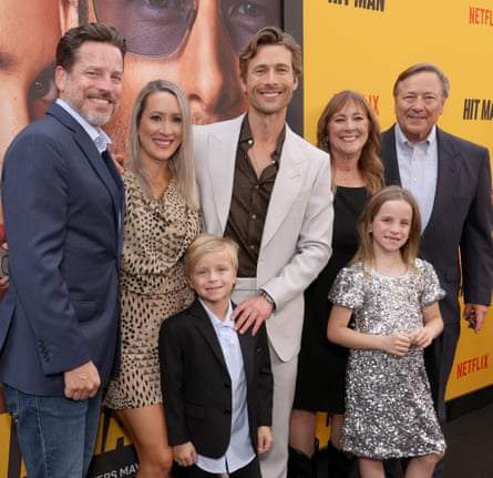 Glen Powell, centre,  standing in front of Hit Man posters with his parents on his left and one of his sisters and her husband and two of her children on his right and in front of him