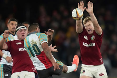 Fin Smith of the British & Irish Lions, right, attempts to block a kick by First Nations & Pacifika XV’s Kurtley Beale.
