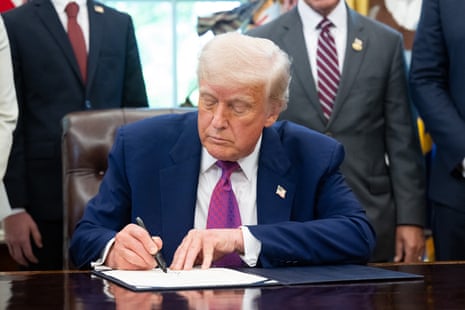 a man in a suit signs a document