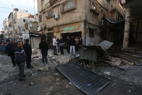 People inspect the damage to buildings after an Israeli drone strike in Tulkarm