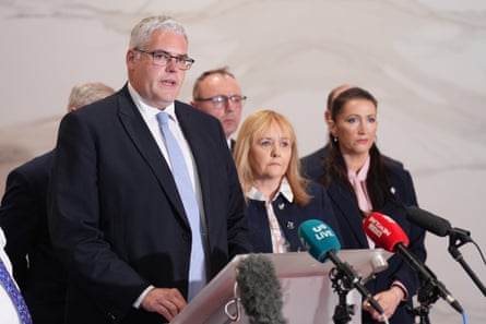 The DUP leader, Gavin Robinson, speaks to the media in Belfast, as the deputy first minister Emma Little-Pengelly (right) listens as others look on