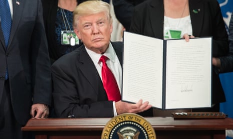Donald Trump signs an executive order to start the Mexico border wall project on Wednesday.